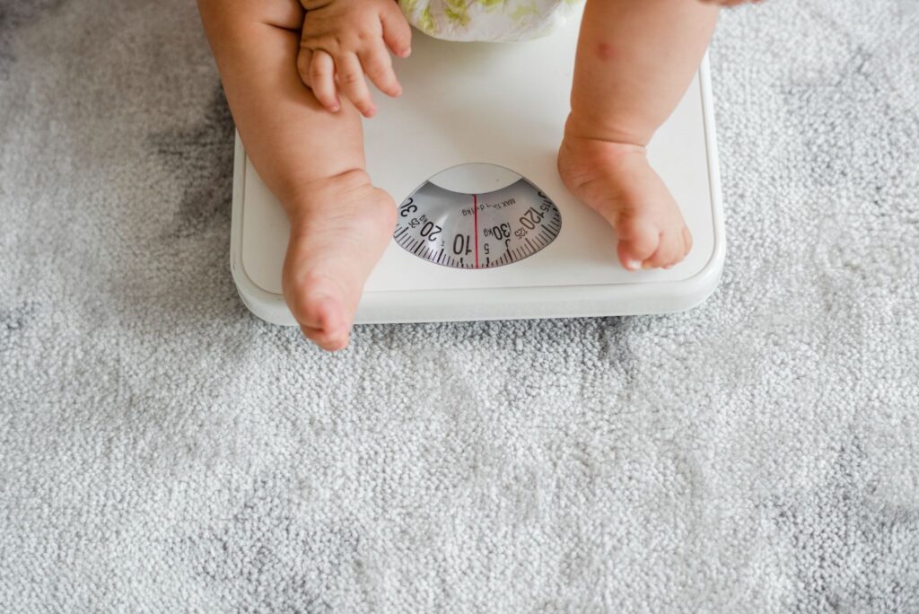 Baby on a weighing scale for monitoring weight growth